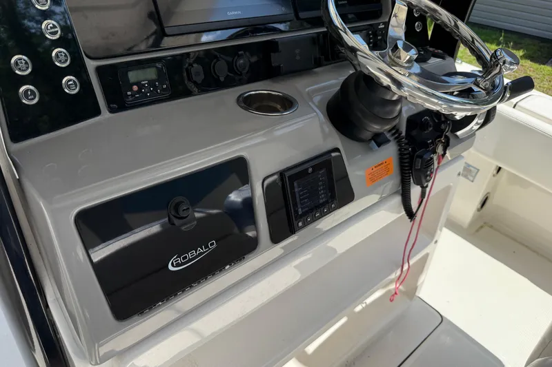 Slide: The Image of 2022 Robalo 266 Cayman boat dashboard with steering wheel and control panel. - 6