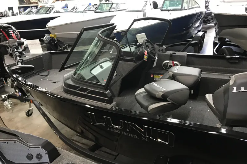 Slide: The Image of 2026 Lund 1650 Rebel XL Sport boat interior with seating and steering console. - 15