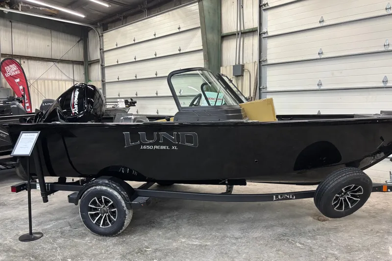 The Image of 2026 Lund 1650 Rebel XL Sport boat displayed indoors on a trailer. - 7