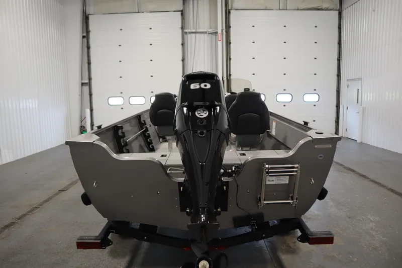 Slide: The Image of 2026 Crestliner 1650 Kodiac SC boat in a garage, rear view with motor. - 5