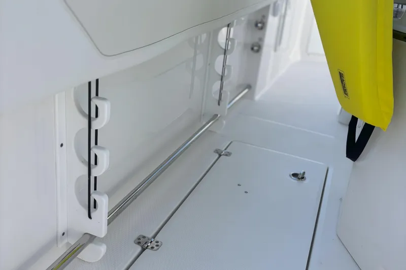 Slide: The Image of 2024 Edgewater 262CC boat interior with rod holders and yellow life jacket. - 21