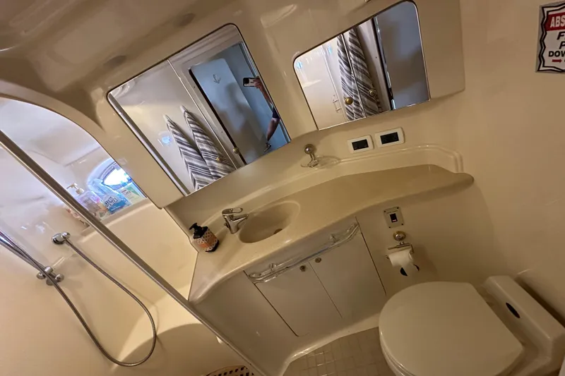 Slide: The Image of Bathroom interior of 2001 Sea Ray 510 Sundancer yacht, featuring sink, toilet, and shower. - 23