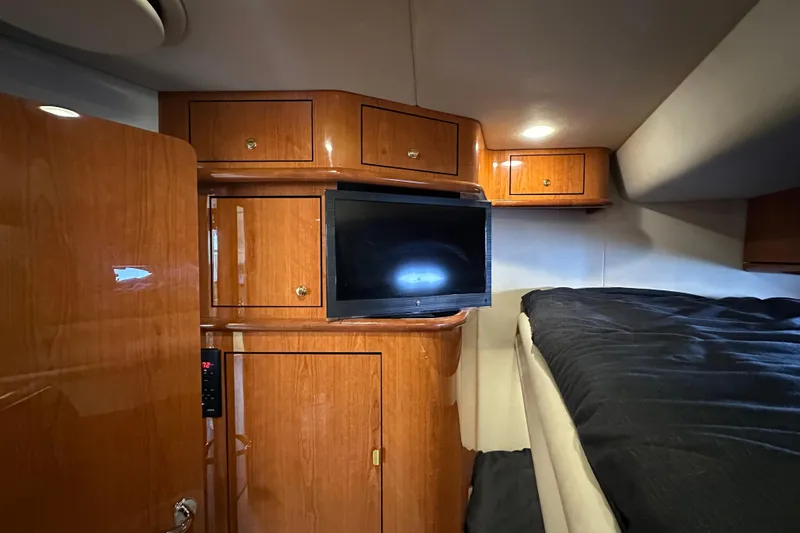 Slide: The Image of Luxurious cabin interior of 2001 Sea Ray 510 Sundancer with wood cabinetry and TV. - 26
