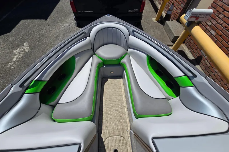 Slide: The Image of 2023 Sanger V215 boat interior with gray and green seating, cup holders, and carpeted floor. - 10