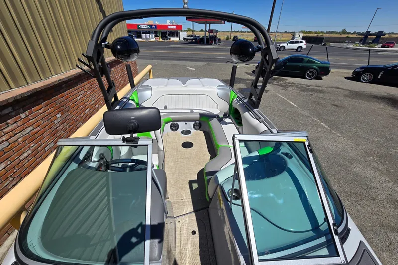 Slide: The Image of 2023 Sanger V215 boat interior with green accents, parked near a brick wall. - 11