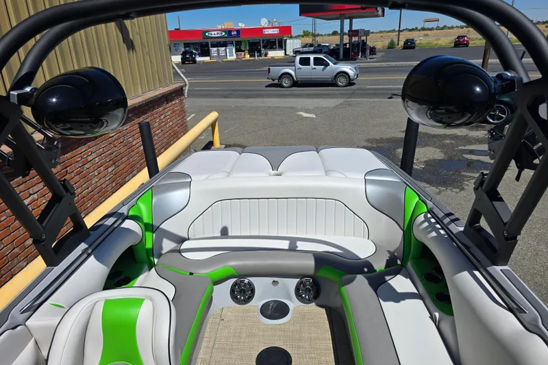 Slide: The Image of 2023 Sanger V215 boat interior with green accents, parked near a street. - 12