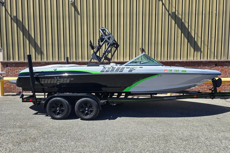 Slide: The Image of 2023 Sanger V215 boat on trailer, black and green design, parked outdoors. - 21