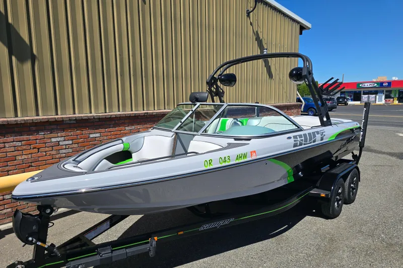 Slide: The Image of 2023 Sanger V215 boat with sleek design, parked on a trailer outside a building. - 25