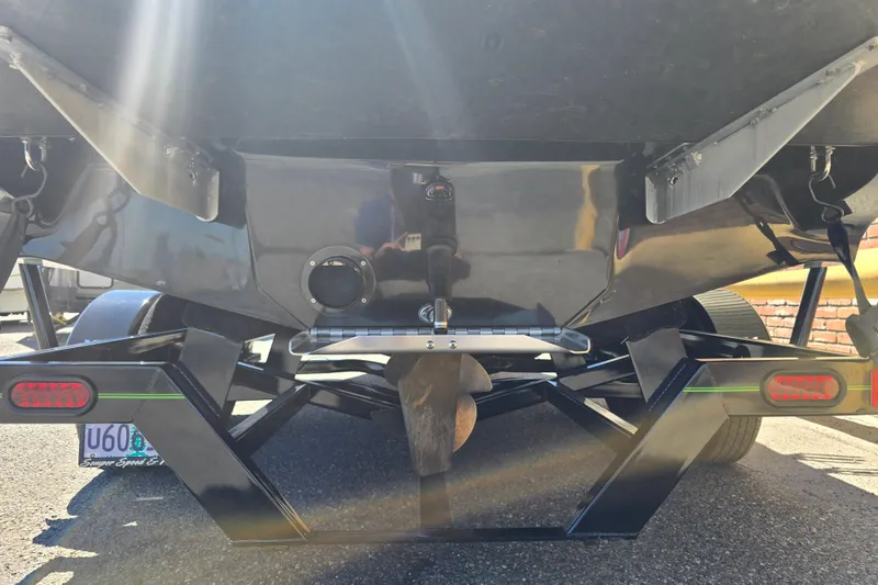Slide: The Image of Rear view of 2023 Sanger V215 boat on trailer, showcasing propeller and hull details. - 29