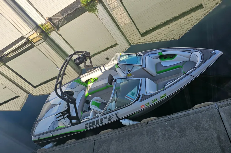 Slide: The Image of 2023 Sanger V215 boat docked, featuring sleek design and green accents. - 3