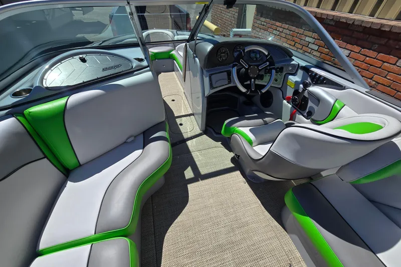 Slide: The Image of 2023 Sanger V215 boat interior with green and gray seating, modern dashboard, and steering wheel. - 33