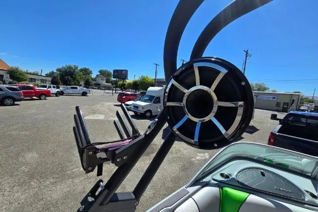 Slide: The Image of 2023 Sanger V215 boat with wakeboard tower and speaker in a parking lot. - 9