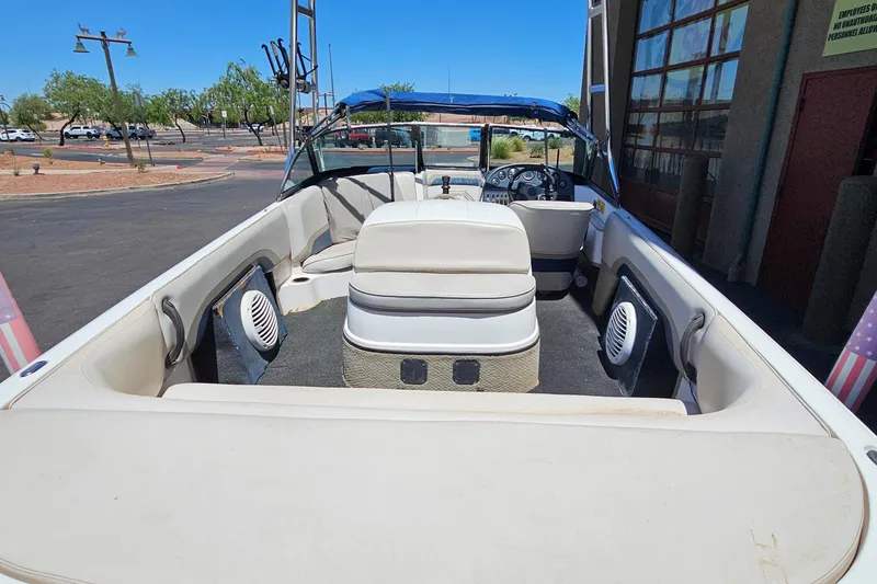 Slide: The Image of 2001 Moomba Outback boat interior with seating and speakers, parked outdoors. - 3
