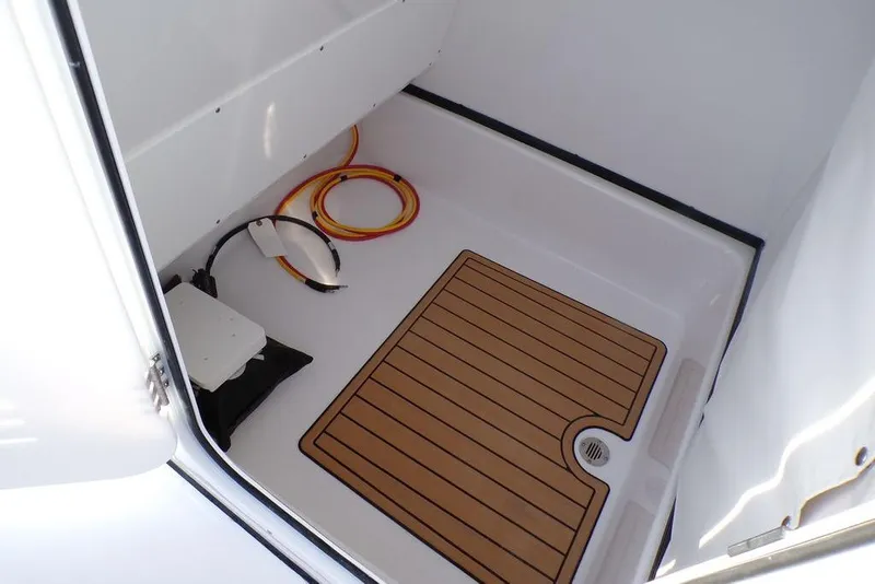 Slide: The Image of 2025 Sportsman Masters 247 boat storage compartment with wooden mat and coiled cables. - 35