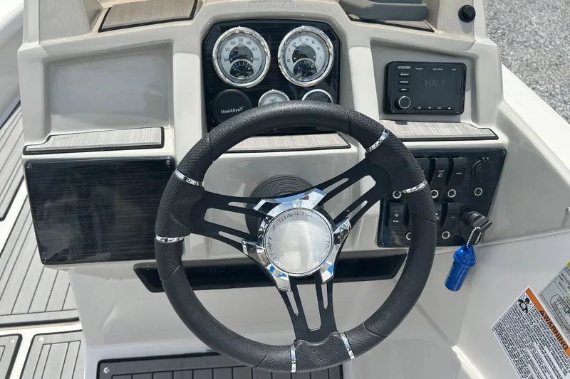 Slide: The Image of 2023 Starcraft SVX 231 OB DH boat dashboard with steering wheel and control panel. - 25