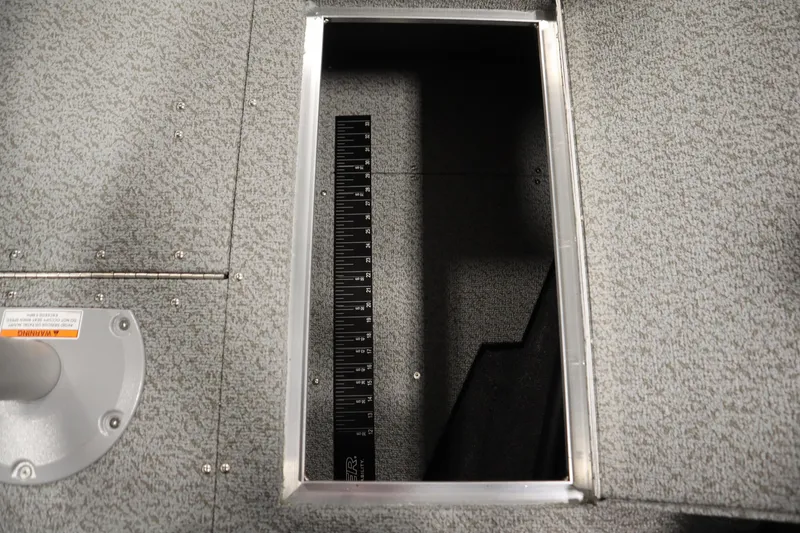 Slide: The Image of 2026 Crestliner 1650 Hawk Side Console boat storage compartment with measuring ruler. - 17