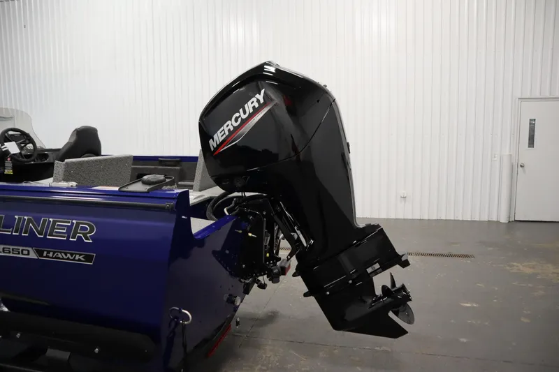 Slide: The Image of 2026 Crestliner 1650 Hawk Side Console boat with Mercury outboard motor in a showroom. - 43
