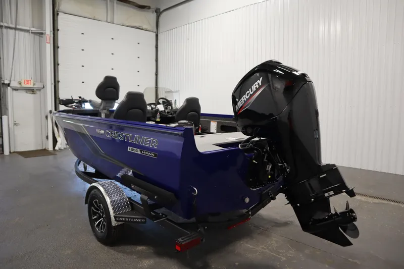 Slide: The Image of 2026 Crestliner 1650 Hawk Side Console boat with Mercury outboard motor in a garage. - 6