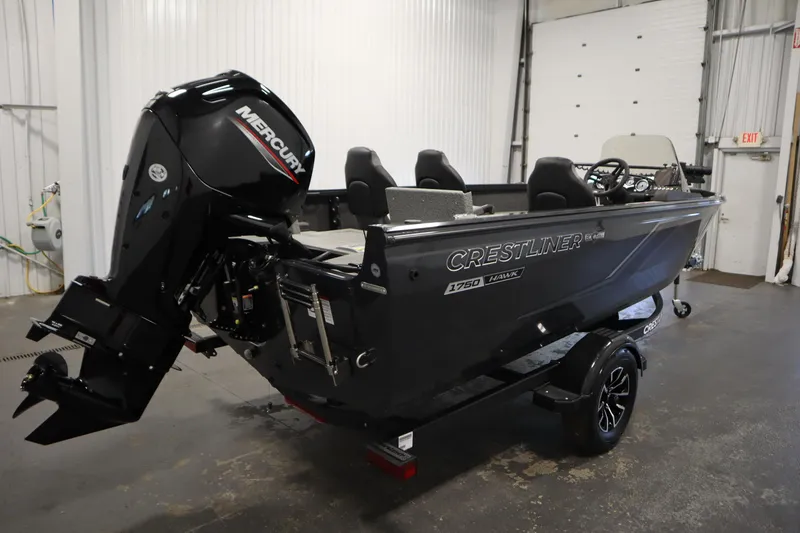 Slide: The Image of 2026 Crestliner 1750 Hawk Side Console boat with Mercury engine in a garage setting. - 4