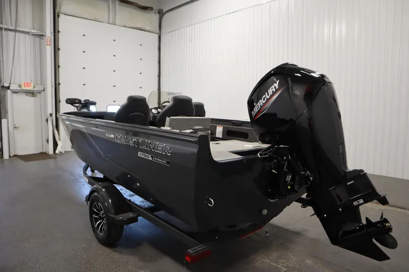 Slide: The Image of 2026 Crestliner 1750 Hawk Side Console boat with Mercury engine in a garage setting. - 6