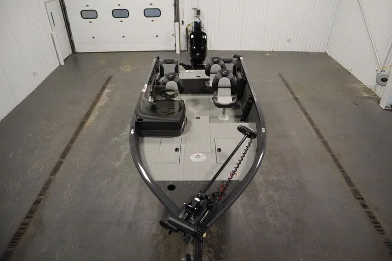 Slide: The Image of 2026 Crestliner 1750 Hawk Side Console boat in a garage, showcasing interior seating and controls. - 8