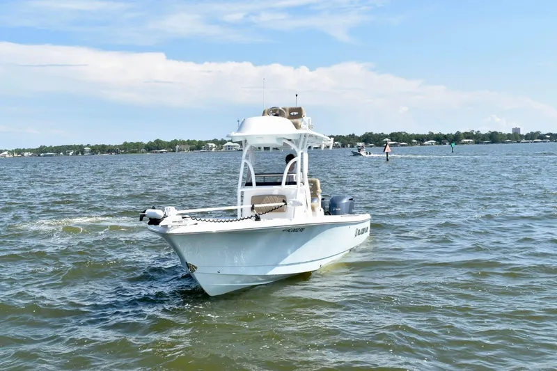 Slide: The Image of 2021 Blazer Bay 2700 Hybrid Bay boat on open water under clear sky. - 2