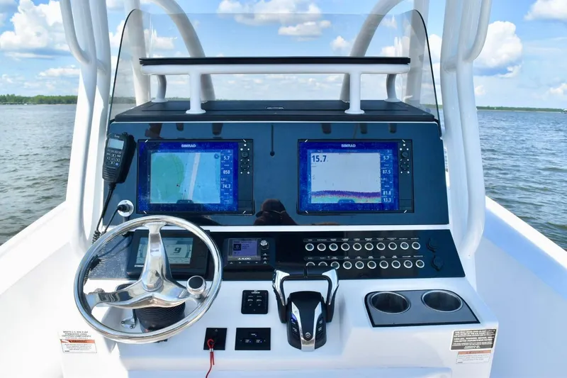 Slide: The Image of 2021 Blazer Bay 2700 Hybrid Bay boat dashboard with navigation screens and controls. - 5