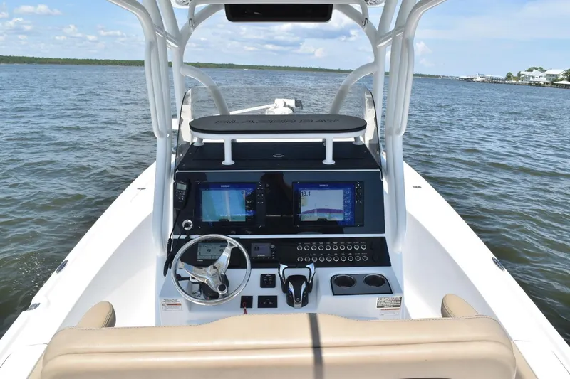 Slide: The Image of 2021 Blazer Bay 2700 Hybrid Bay boat dashboard with navigation screens on open water. - 6