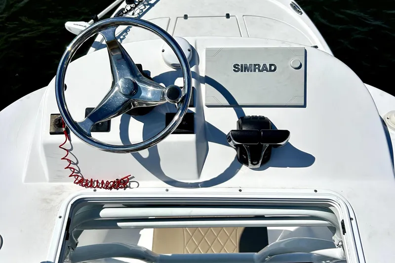 Slide: The Image of 2021 Blazer Bay 2700 Hybrid Bay boat helm with steering wheel and Simrad display. - 7