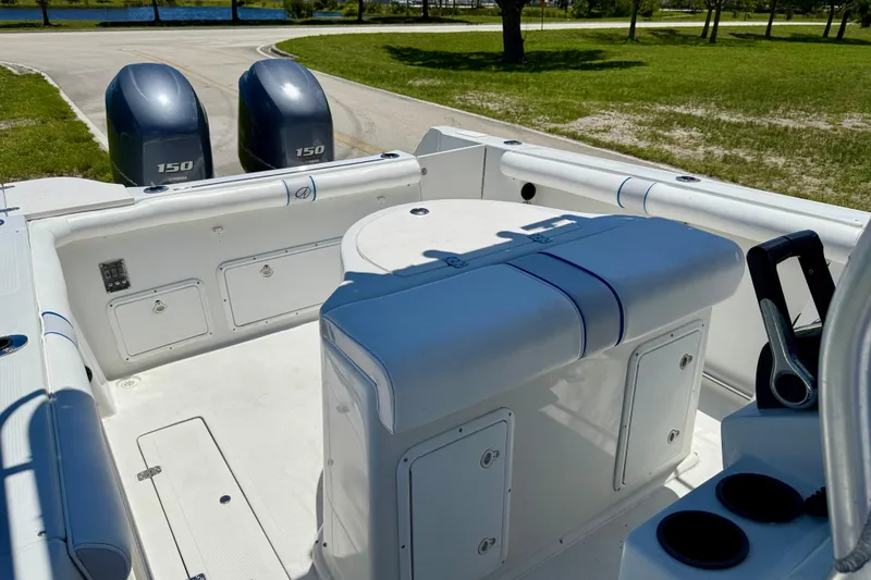 Slide: The Image of 2003 Sailfish 266 CC boat interior with dual Yamaha 150 engines, docked near a grassy area. - 13