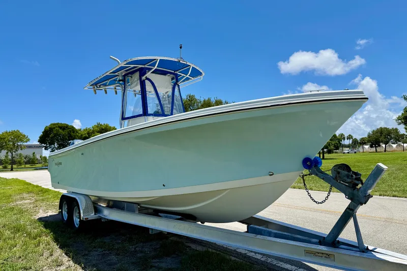 Slide: The Image of 2003 Sailfish 266 CC boat on trailer under clear blue sky. - 2