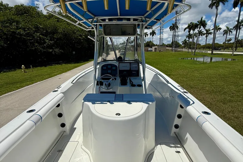 Slide: The Image of 2003 Sailfish 266 CC boat with blue canopy, steering console, and open deck. - 25