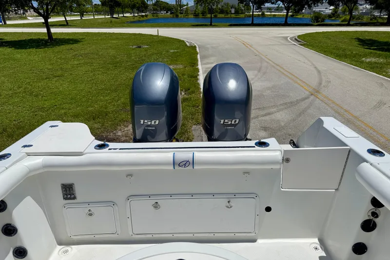 Slide: The Image of 2003 Sailfish 266 CC boat with twin Yamaha 150 engines, parked on a road. - 27