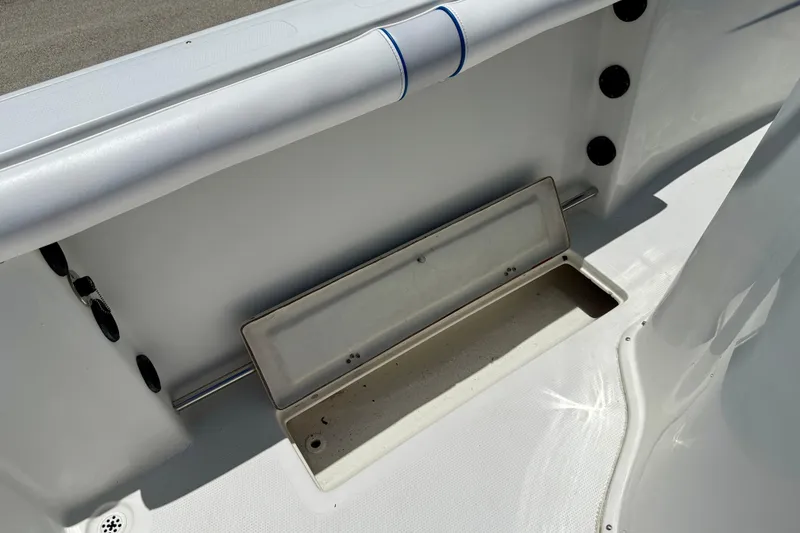Slide: The Image of 2003 Sailfish 266 CC boat interior with open storage compartment and rod holders. - 29