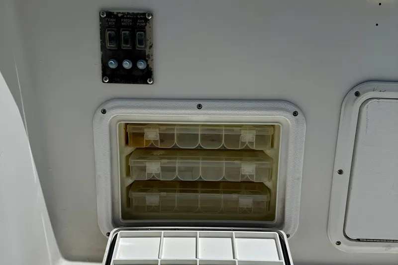 Slide: The Image of Control panel and storage compartments on a 2003 Sailfish 266 CC boat. - 30