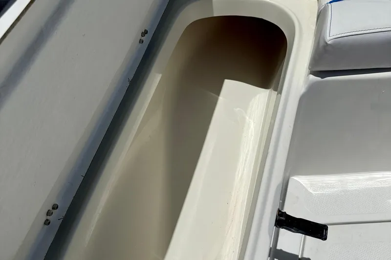 Slide: The Image of Open storage compartment on a 2003 Sailfish 266 CC boat, featuring white interior. - 32