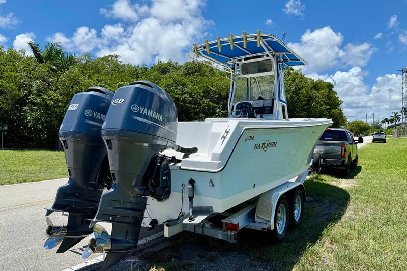 Slide: The Image of 2003 Sailfish 266 CC boat with twin Yamaha engines on a trailer, parked roadside. - 4