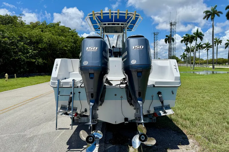 Slide: The Image of 2003 Sailfish 266 CC boat with dual Yamaha 150 engines, parked on a sunny day. - 5