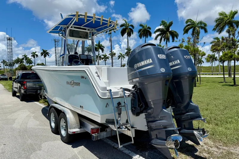 Slide: The Image of 2003 Sailfish 266 CC boat with twin Yamaha 150 engines on trailer, palm trees in background. - 6