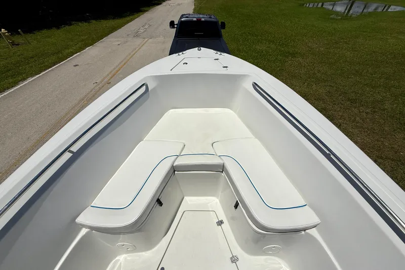 Slide: The Image of 2003 Sailfish 266 CC boat interior with white seating, parked on a road. - 7