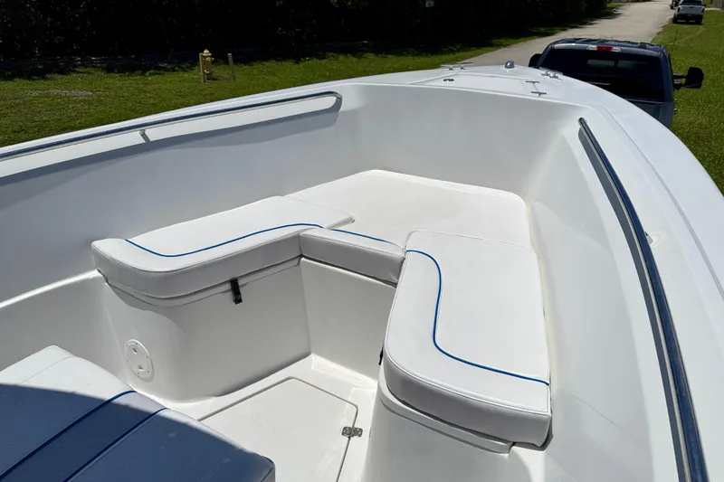 Slide: The Image of 2003 Sailfish 266 CC boat interior with white cushioned seating and blue trim. - 8