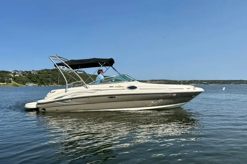 Slide: The Image of 2006 Sea Ray 240 Sundeck boat cruising on a calm lake under clear skies. - 12