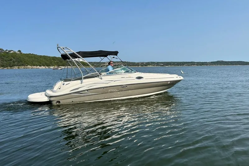 Slide: The Image of 2006 Sea Ray 240 Sundeck boat cruising on a calm lake under clear skies. - 13