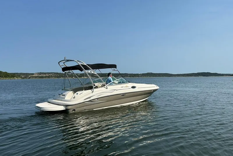 Slide: The Image of 2006 Sea Ray 240 Sundeck boat cruising on a calm lake under clear skies. - 14