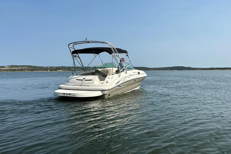 Slide: The Image of 2006 Sea Ray 240 Sundeck boat cruising on a calm lake under clear skies. - 15