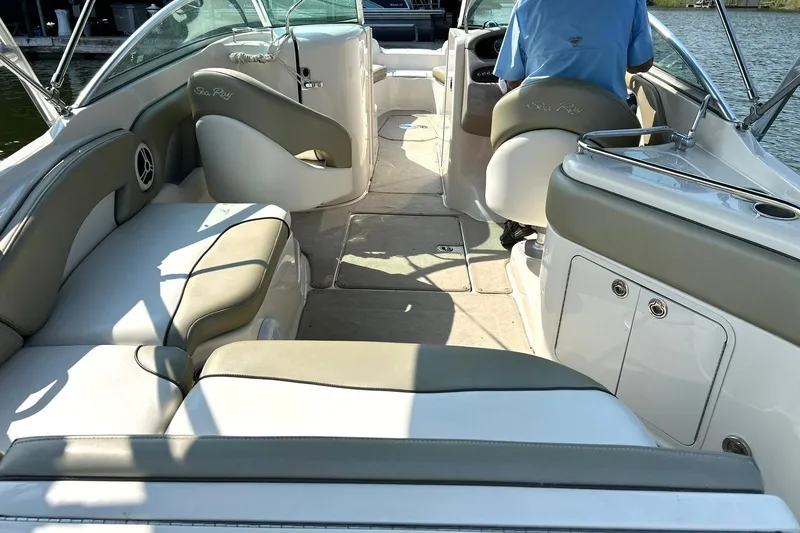 Slide: The Image of 2006 Sea Ray 240 Sundeck interior with beige and white seating, spacious layout. - 18