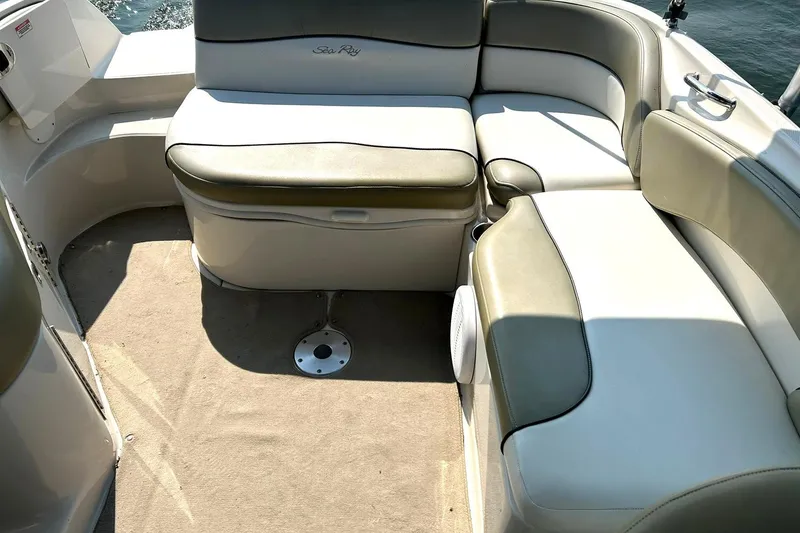 Slide: The Image of 2006 Sea Ray 240 Sundeck interior with cushioned seating and carpeted floor. - 22