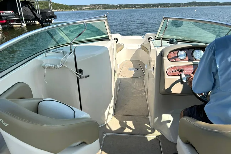 Slide: The Image of 2006 Sea Ray 240 Sundeck interior with steering console, lake view, and seating area. - 26