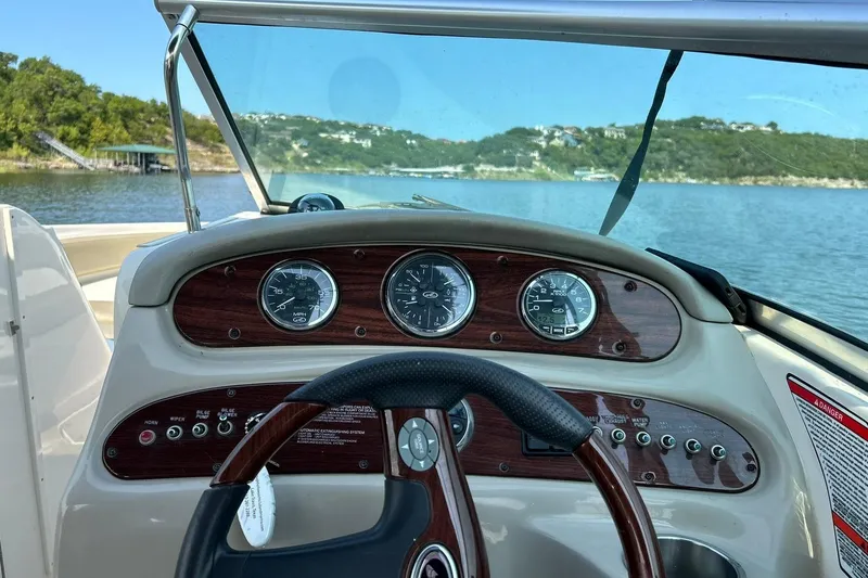 Slide: The Image of Dashboard view of a 2006 Sea Ray 240 Sundeck boat on a scenic lake. - 29