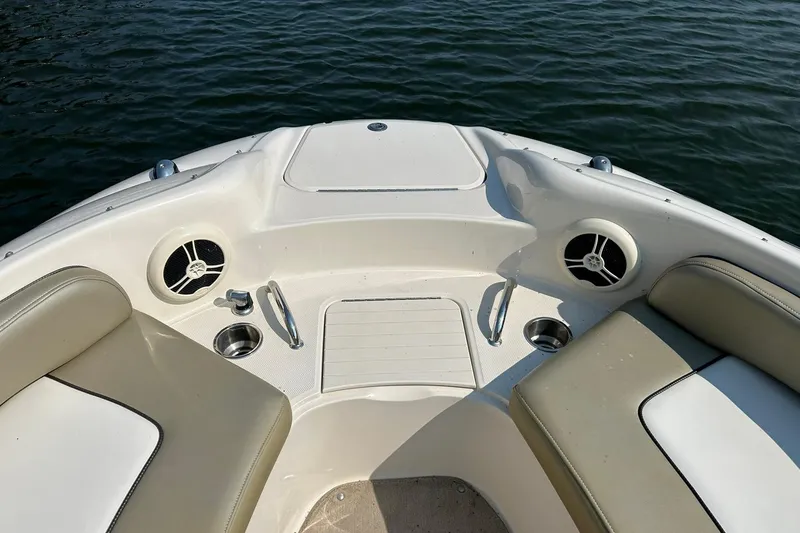 Slide: The Image of 2006 Sea Ray 240 Sundeck boat interior with seating and cup holders on water. - 32